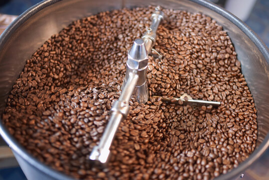 close up view of coffee beans roasting in machine