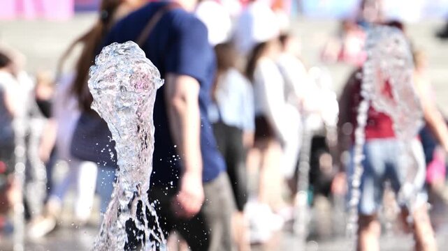 Water splashing from a fountain while people enjoy a refreshing day in the city