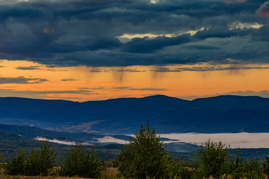 Misty Carpathian Mountains at sunrise. Fog drifting through mountain valleys. rain over mountains