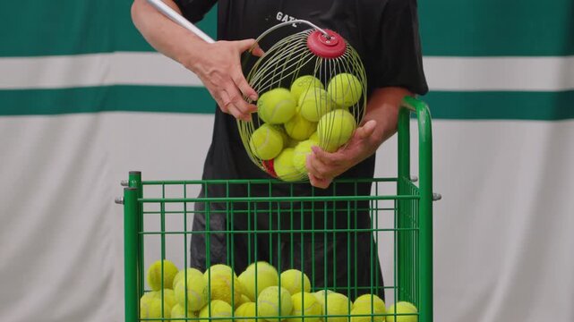 Players pour tennis balls from the roller ball picker into the golf cart