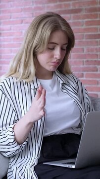 Frustrated blonde businesswoman finishing her remote work on a laptop, closing the computer with a sigh of disappointment and sadness after receiving bad news or failing at a task
