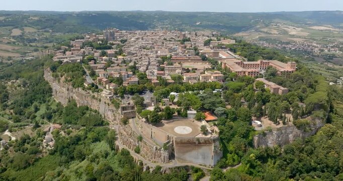 Aerial panoramic view of the historic hilltop town of Orvieto, built atop a volcanic tuff cliff, in the province of Terni, Umbria, Italy. The medieval old town overlooks rolling hills and countryside.