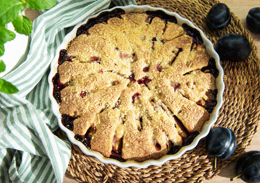 Baked plum dessert with crumb topping on rustic table