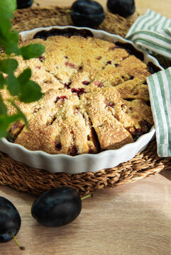 Baked plum dessert with crumb topping on rustic table