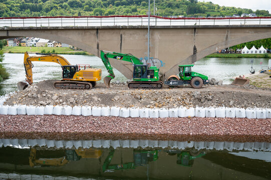 Construction site, excavators and road roller, temporary bank reinforcement, sandbags and crushed stone, bridge Wasserbillig, Luxembourg