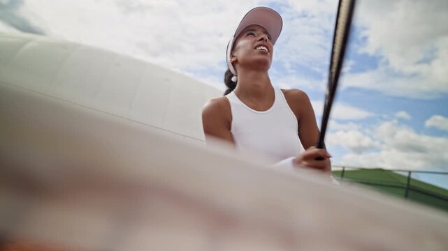 Biracial young woman playing tennis, hitting balls with racket on clay court. Footage suitable for sports marketing, athletic apparel campaigns, fitness videos