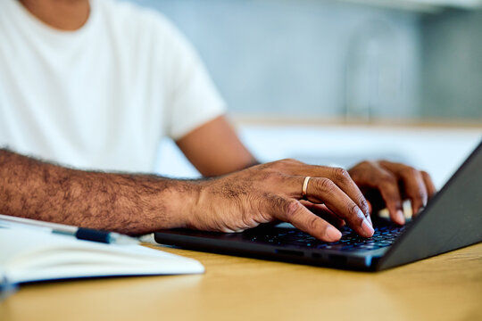 Person's hands working on a laptop computer, typing on the keyboard. Representing remote work, freelance, or online learning