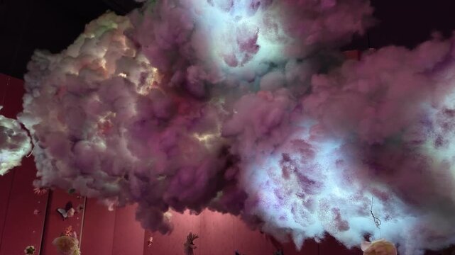 Artificial cotton clouds hanging from ceiling, glowing with internal colorful LED lights