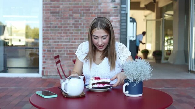 Young woman eats cake after peptide injection portraying a biohacking trend of trying to offset indulgent foods and trick the body while enjoying sugary dessert at a cafe
