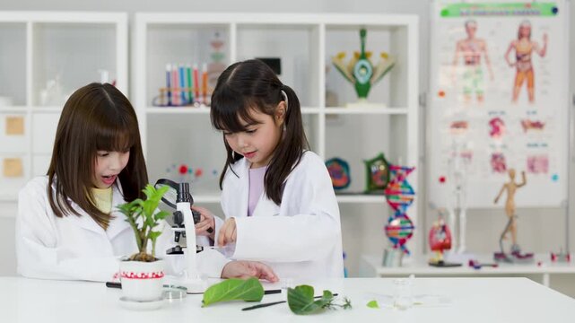 Asian Elementary Students in Lab Coats Studying Biology with Microscope
