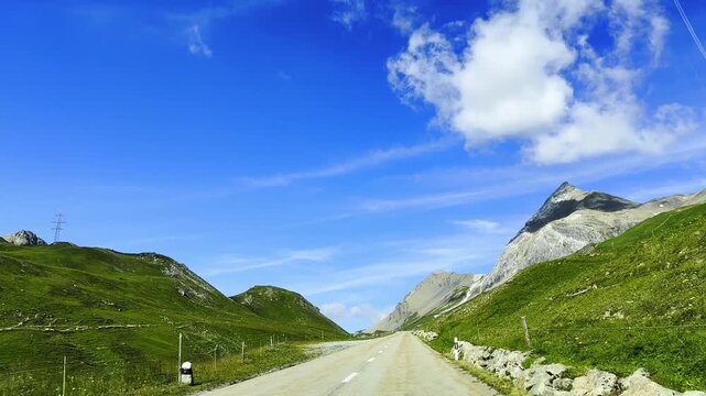 Beautiful Mountain Road in the Swiss Alps in a Sunny Summer Day with Blue Sky and Clouds in Albula Pass, Grisons, Switzerland.