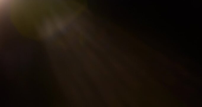 Slow motion of lens flare isolated on black background. Anamorphic lens. Cinematic glowing light overlay with optical streaks and rays for VFX compositing and transitions.