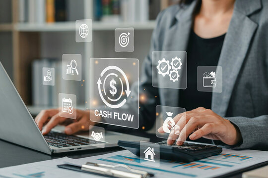 Businesswoman managing finances on laptop and calculator with cash flow