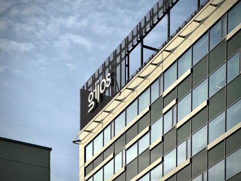 Low-angle photo of the "gijos" sign (Vilniaus &Scaron;ilumos Tinklai) on a modern office building facade in Vilnius, Lithuania. Ideal for stock photo needs related to district heating, energy utilities 