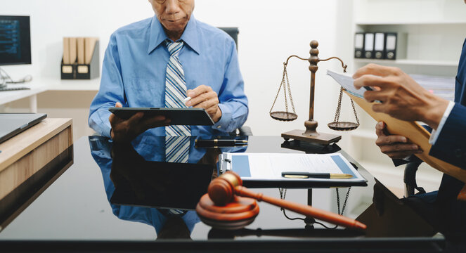 business people and lawyers discussing contract papers sitting at the table. Concepts of law, advice, legal services.