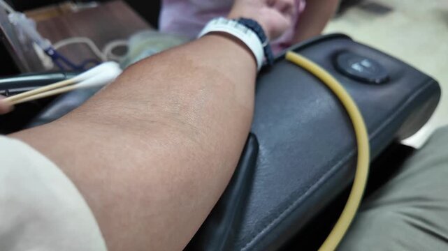 A nurse disinfects a donor arm before blood donation.