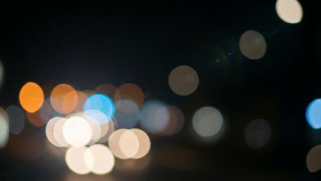softly blurred street lights at night creating a dreamy abstract background with colorful circles of light for creative use in design projects.