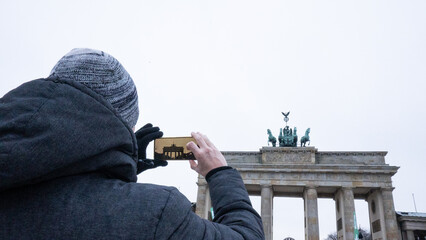 Tourist capturing brandenburg gate with smartphone in berlin © Arianne