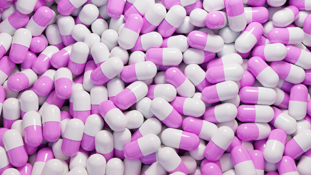 Pink and white capsule pills closely packed in a pile