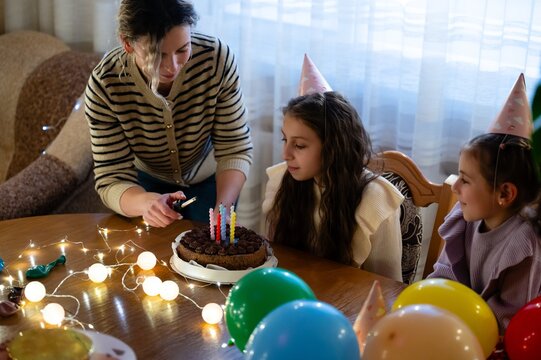 Celebration of a birthday with joyful children surrounded by colorful balloons and sweet treats in a cozy indoor setting