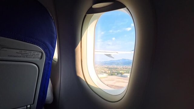 Airplane Window View as the Aircraft Takes Off and Rises Above the Runway, Flight - STEADY VIDEO - NO AUDIO