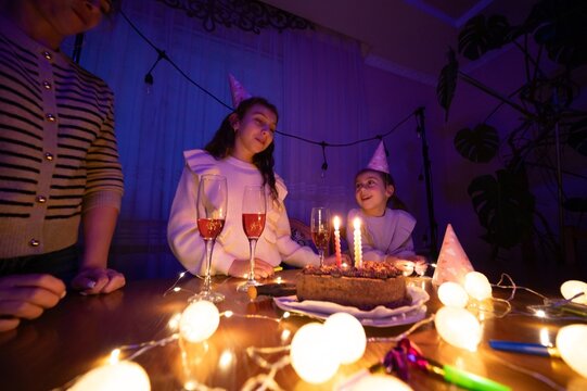 Celebrating a joyful birthday party with candles glowing and laughter echoing in a cozy, warmly lit room filled with festive decorations and cheerful vibes