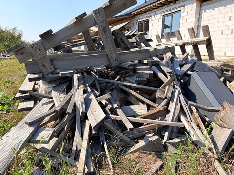 A pile of discarded wooden planks and pallets at a construction site.