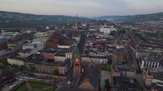Aerial view of the historic Guildhall clock tower and surrounding urban architecture in the city center of Derry, Northern Ireland, United Kingdom.