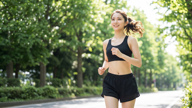 爽やかな朝の光を浴びて笑顔でランニングする女性