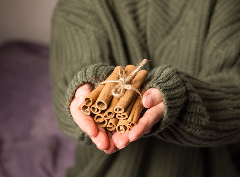 Hands holding cinnamon sticks, hands holding aromatic cinnamon sticks, spice theme, cinnamon theme, culinary theme