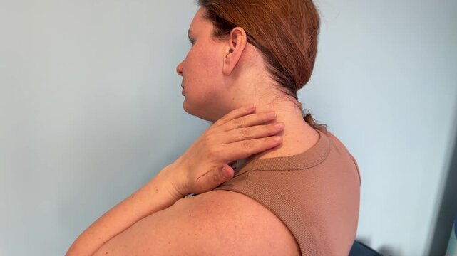 Side view of a caucasian woman holding her hair up to show three red inflamed insect bites on her neck