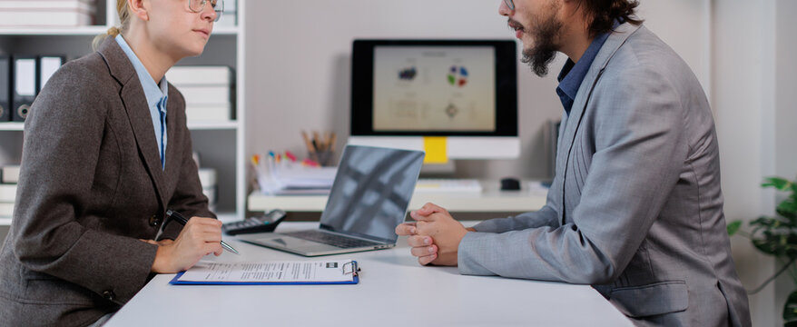 Human resources manager conducting a job interview with a male candidate, discussing professional qualifications and career goals during a recruitment meeting in an office