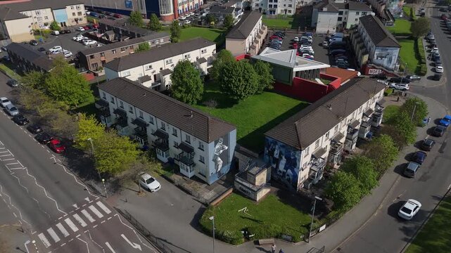 Aerial view of residential buildings featuring large murals in a neighborhood in Londonderry, United Kingdom.