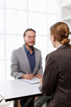 Professional man interviewing job applicant in modern office, discussing employment and recruitment process, evaluating candidate for new career opportunity