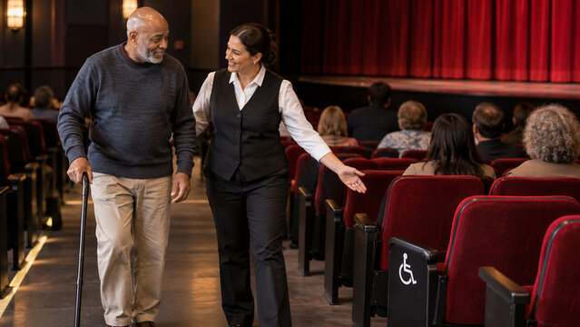 Usher Guiding Cane User Toward Accessible Theater Seat