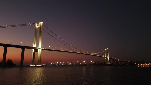 Cinematic clip during the early hours of nightfall of the magnificent Maputo-Katembe Bridge lit up as the last of the sunset sinks into the horizon