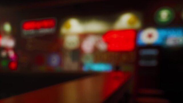 People are seated at a bar, talking and laughing. Bright signs light up the walls. It is night, creating a lively atmosphere with music in the background.