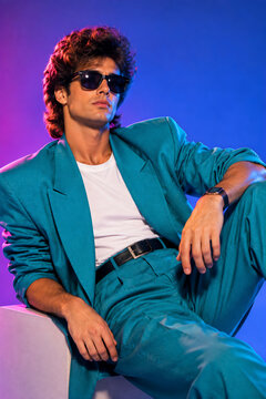 Stylish Man in Retro 80s Suit with Sunglasses on Neon Blue Purple Background