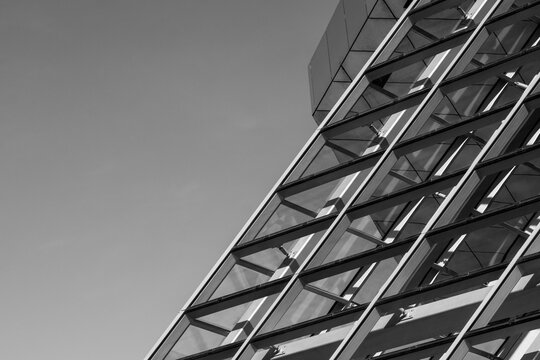 Architectural facade rises diagonally against the sky where a structural grid creates repetition and modern urban geometry across the building exterior