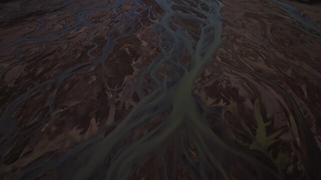 Cinematic aerial flight above braided glacial rivers in Iceland&rsquo;s remote Highlands revealing intricate river channels volcanic terrain and colorful landscapes near the Rainbow Mountains.