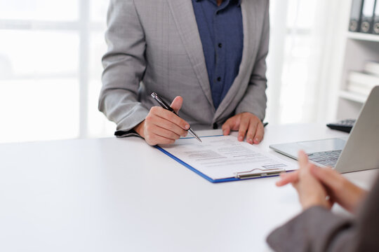 Business professional signing contract or application during interview, human resources manager recruiting new employee, reviewing cv and making hiring decision, employment paperwork