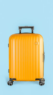 Minimalist studio portrait of a bright yellow plastic travel suitcase isolated on a blue background