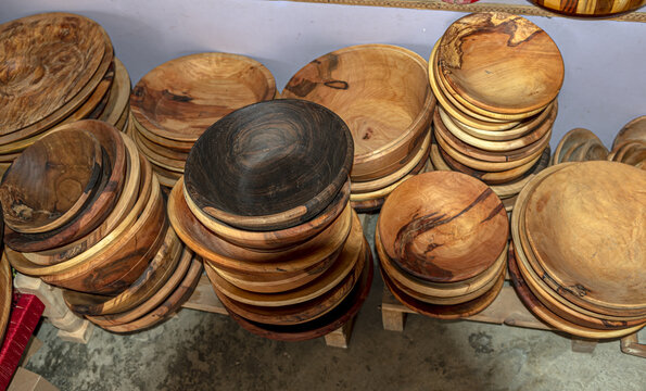 View of handcrafted wooden bowls stacked in a workshop, showcasing natural wood grain patterns and smooth textures in Charbagh, Khyber Pakhtunkhwa, Pakistan.