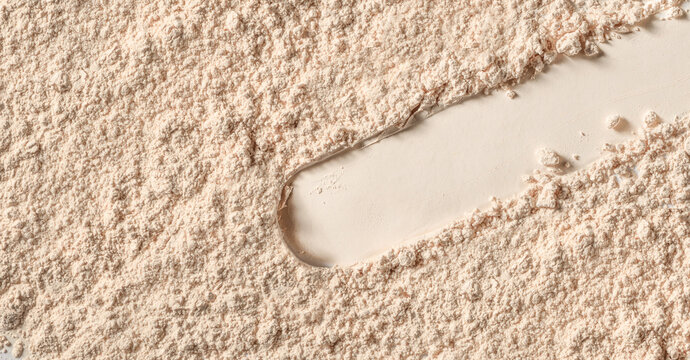 Makeup foundation face powder swatch on textured powder background