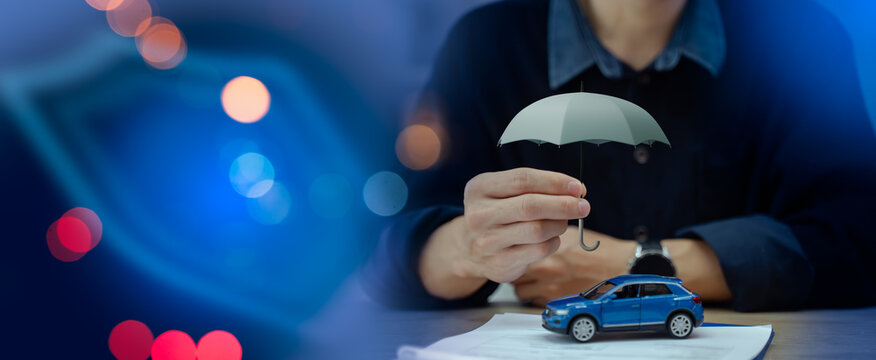 auto insurance policy,vehicle protection,safety coverage,financial business and technology concept.Businessman holding small umbrella over car with glowing virtual shield guard icon on background
