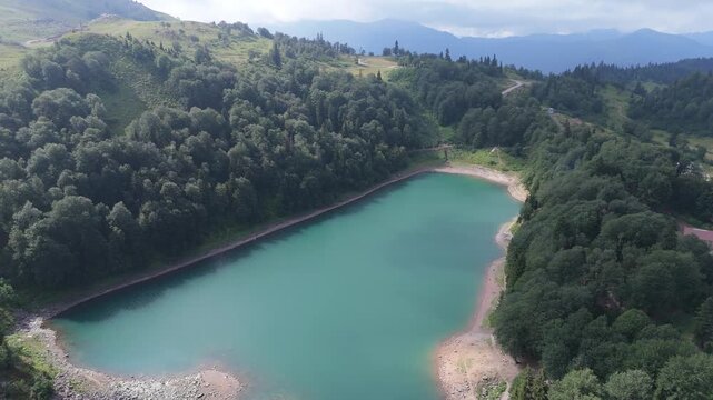  Aerial view green Lake on in Goderdzi Pass Georgia. Alpine Green Lake  in Khulo supporting mountain with forest. Mountain tourism. Freshwater ecology, seasonal travel. 