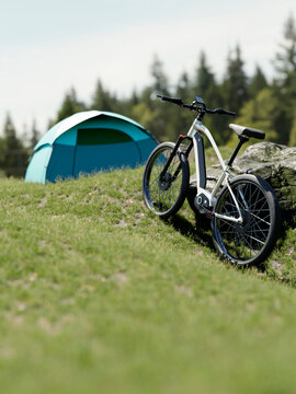 Electric bicycle parked next to a tent in a serene forest clearing