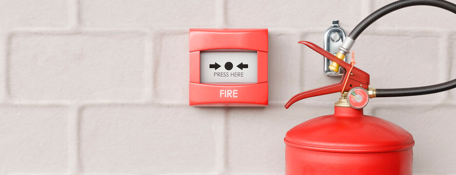 Fire alarm and extinguisher ready for emergency response on a brick wall