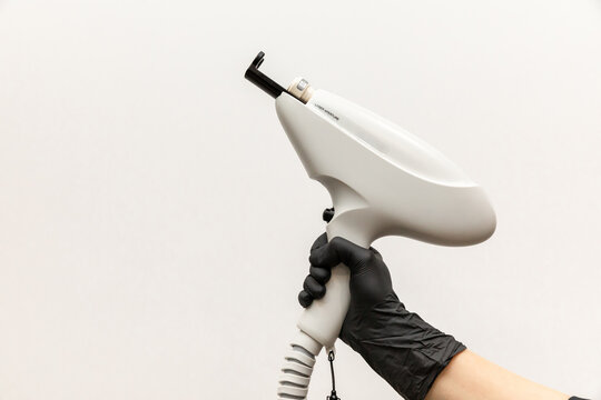 Aesthetic Laser Treatments concept. Doctor hand with laser device, white background. Innovative non-ablative fractional technology for skin photo rejuvenation. Cellular renewal, collagen synthesis