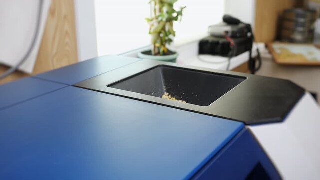Grain sample is poured into a laboratory analyzer for quality testing and analysis in an agricultural lab, showing modern crop inspection and food quality control.